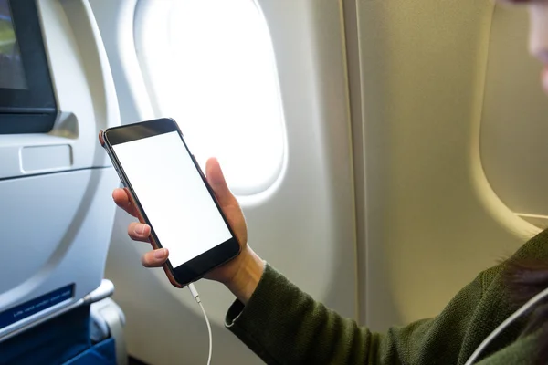 Woman using cellphone inside airplane