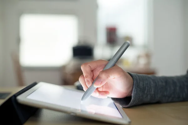 Woman drawing on tablet with pen