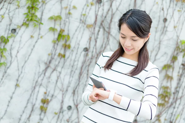 Woman using cellphone and smart watch