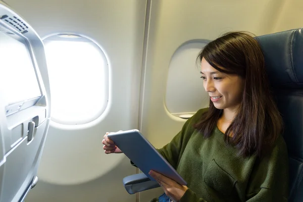 Woman using tablet pc inside aircraft