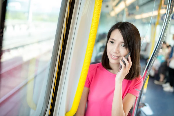 Woman talking on mobile phone in train