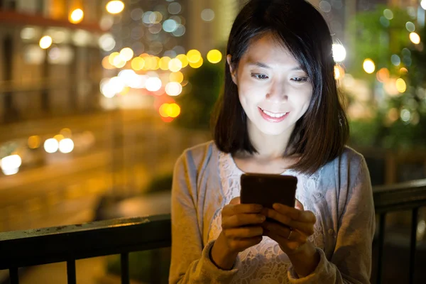 Woman using smart phone at night