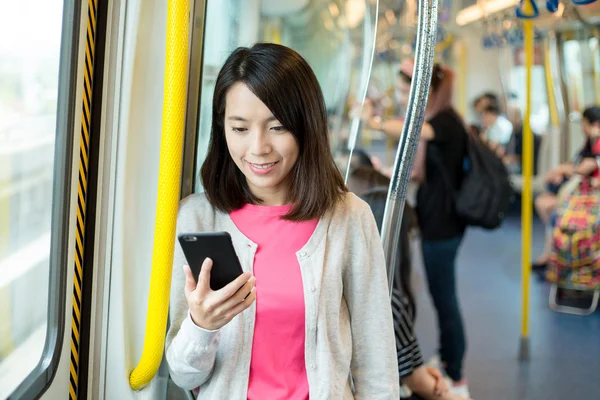 Woman using mobile phone inside train