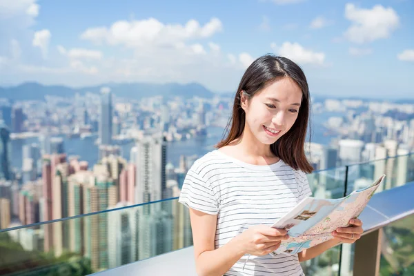 Woman looking at city map in Hong Kong