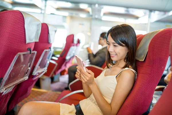 Woman using mobile phone inside ferry