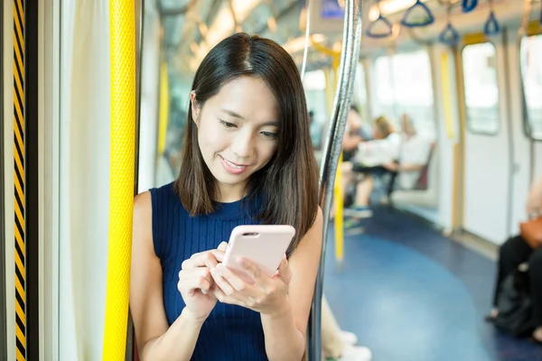 Woman sending text message inside train