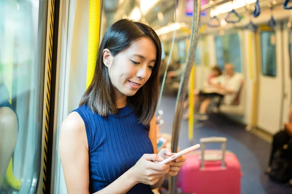 Woman sending text message inside train