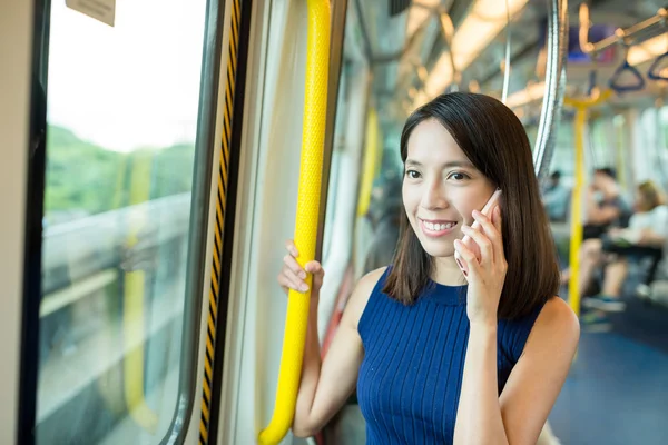 Woman talking on cellphone inside train