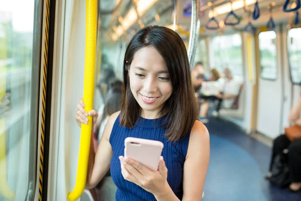 Woman using mobile phone in train