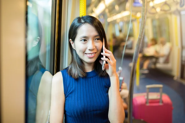 Woman talking on cellphone inside train