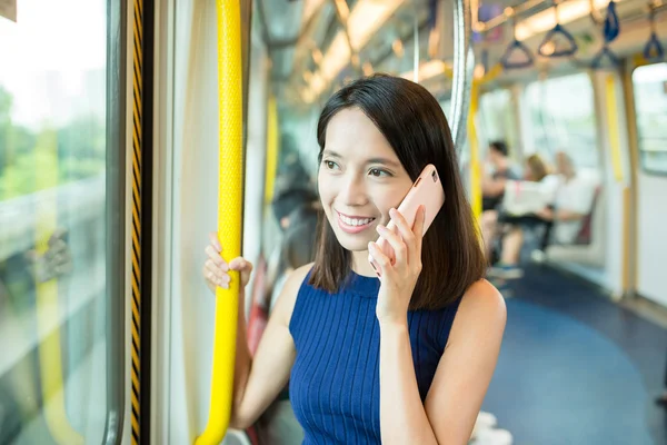 Woman talking on cellphone inside MTR