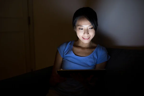 Woman using tablet computer at night