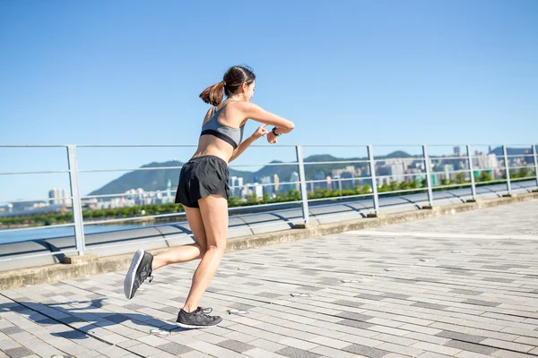 Woman running and using wearable watch