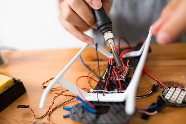 Man using welding to repair drone