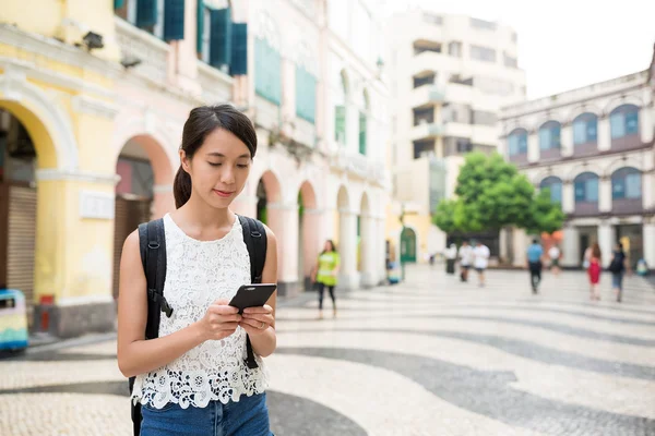 Woman searching something on cellphone in Macau