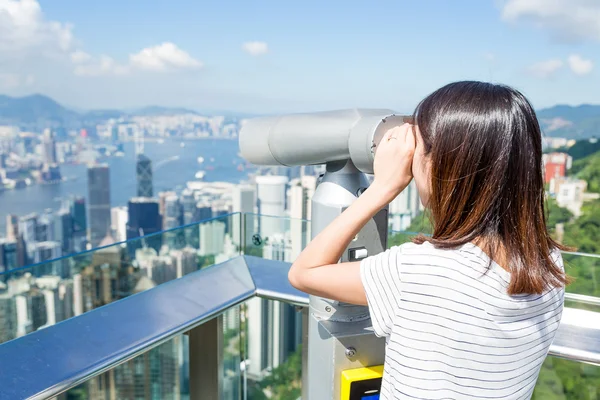 Woman looking though the telescope in the Peak