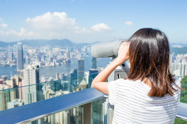 Woman looking though the telescope in the Peak of Hong Kong