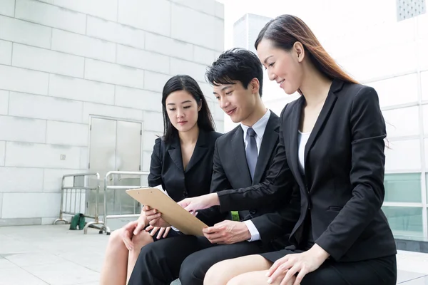 Business team read on clipboard