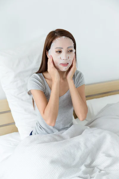 Asian woman using facial mask