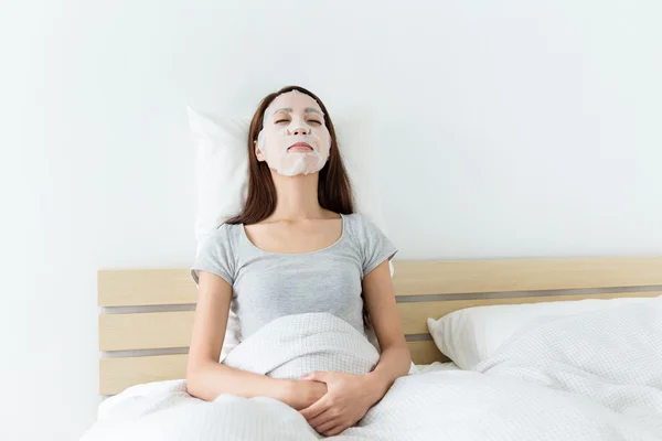 Asian woman using facial mask