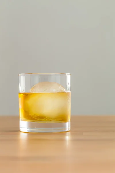 Whiskey drink on table with ice cube