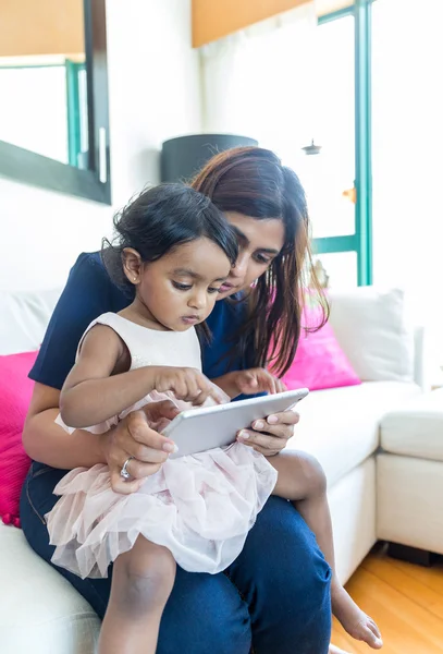 Indian girl play tablet pc with mother