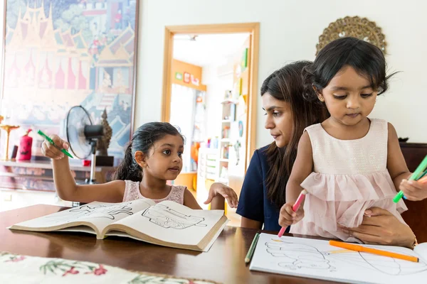 Indian family doing drawing on book