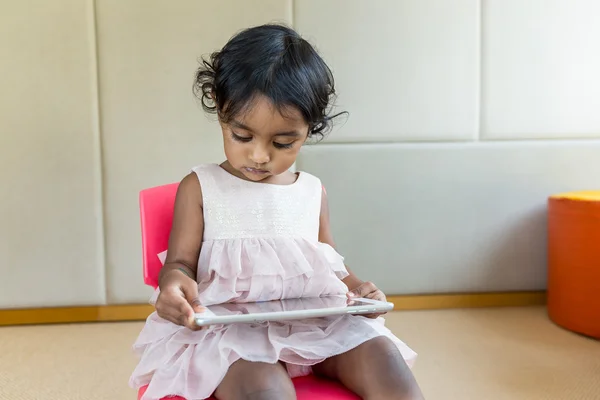 Indian girl reading on tablet pc