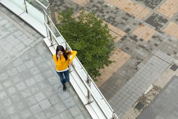 Woman walking on the street and talk to cellphone