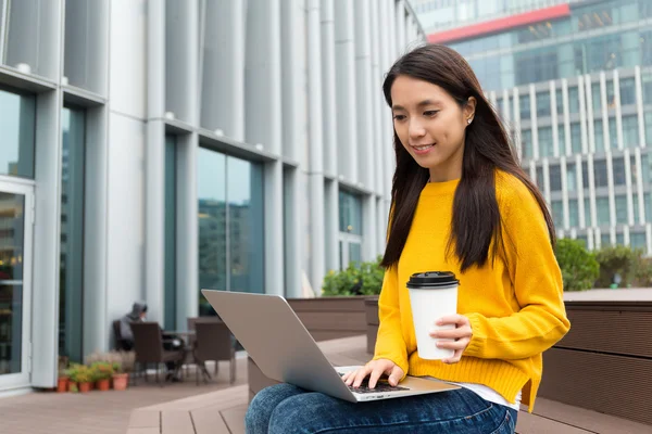 Woman with notebook computer and coffee cup