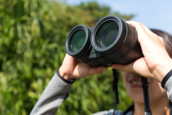 Woman looking through binoculars at outdoors