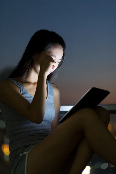 Woman with tablet feeling eye pain