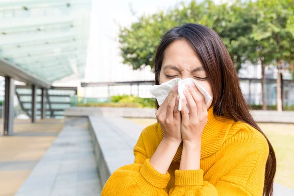 Asian woman blowing nose