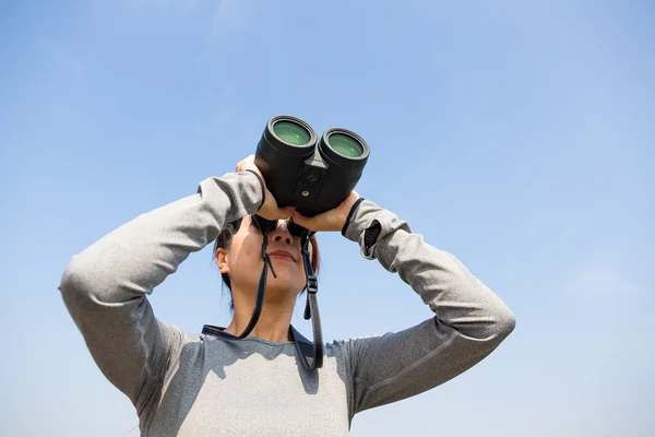 Woman looking through binoculars at outdoors