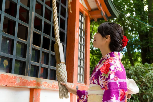 Woman pull the rope to ring the bell