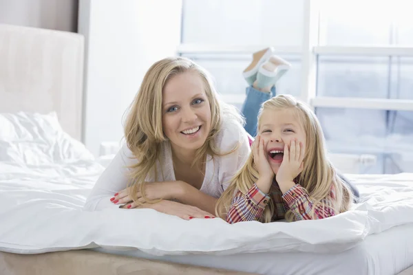 Mother and daughter lying in bed