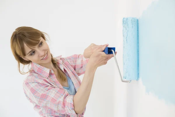 Woman painting wall