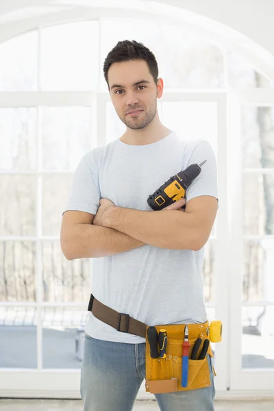 Man with hand drill standing in new house