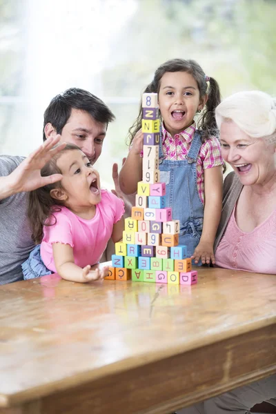 Family with arranged building blocks at table