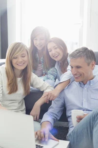 Parents with daughters using laptop