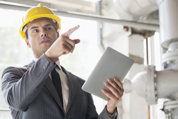 Engineer with digital tablet pointing away