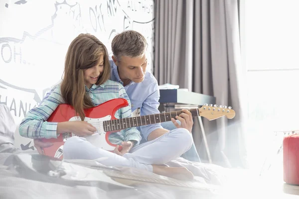 Father and daughter playing guitar