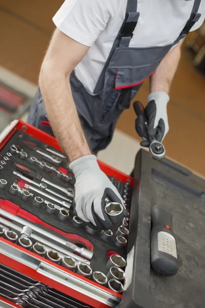 Mechanic arranging tools in drawer