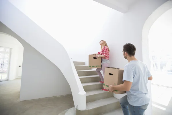 Couple carrying boxes up stairs