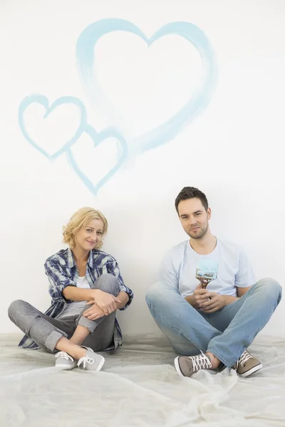 Couple with painted hearts on wall