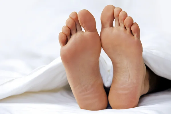 Person\'s feet in bed