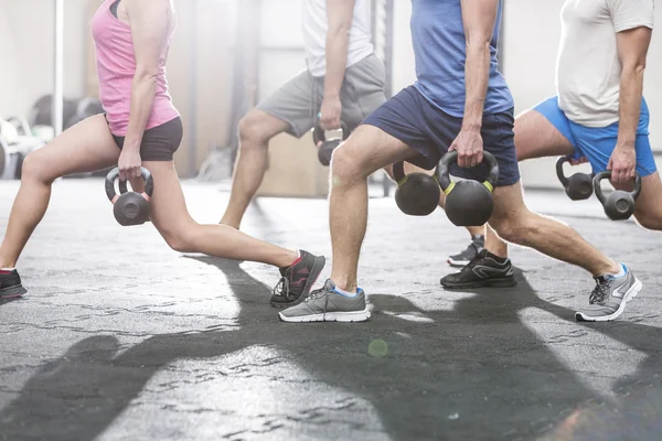 People lifting kettlebells