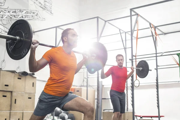 Men lifting barbells