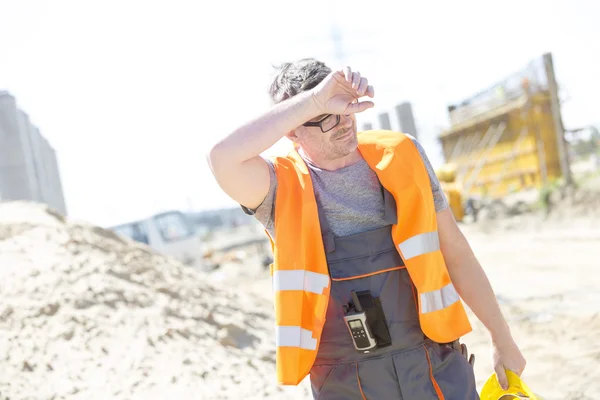 Construction worker wiping forehead
