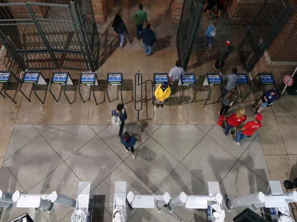 Overhead of fans leave baseball stadium through gates after game